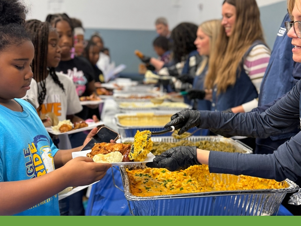 Children picking up plates of food at Day Of Dependability Dinner 