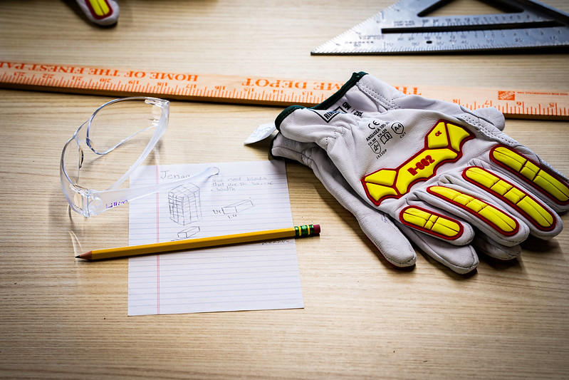 gloves, ruler, pencil and paper on desk