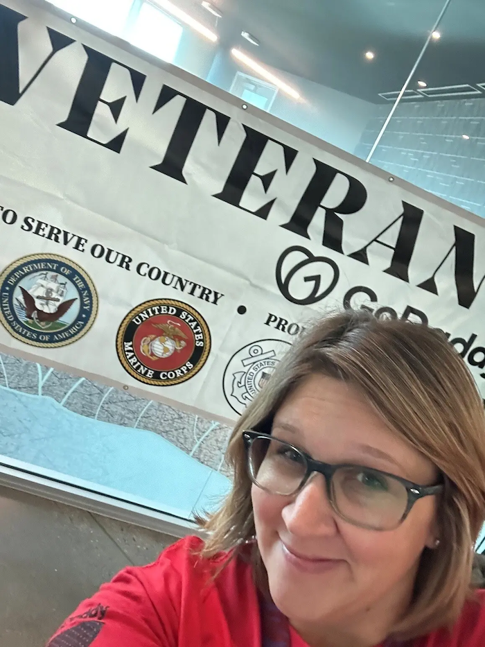 Terah in front of a Veterans banner.