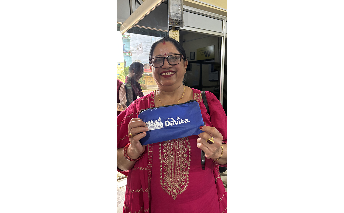Person holding up a blue DaVita bag