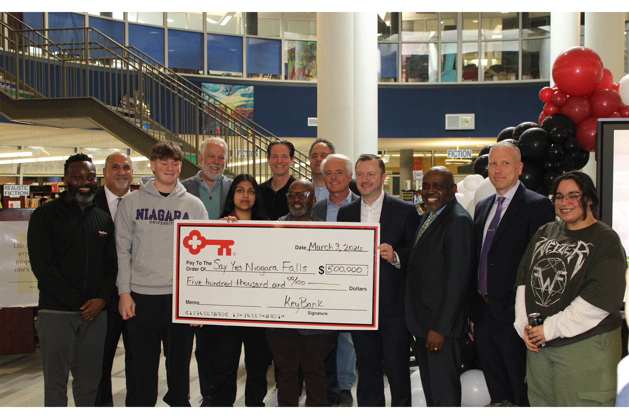 Group holding up oversized check made out to Say Yes Niagara Falls