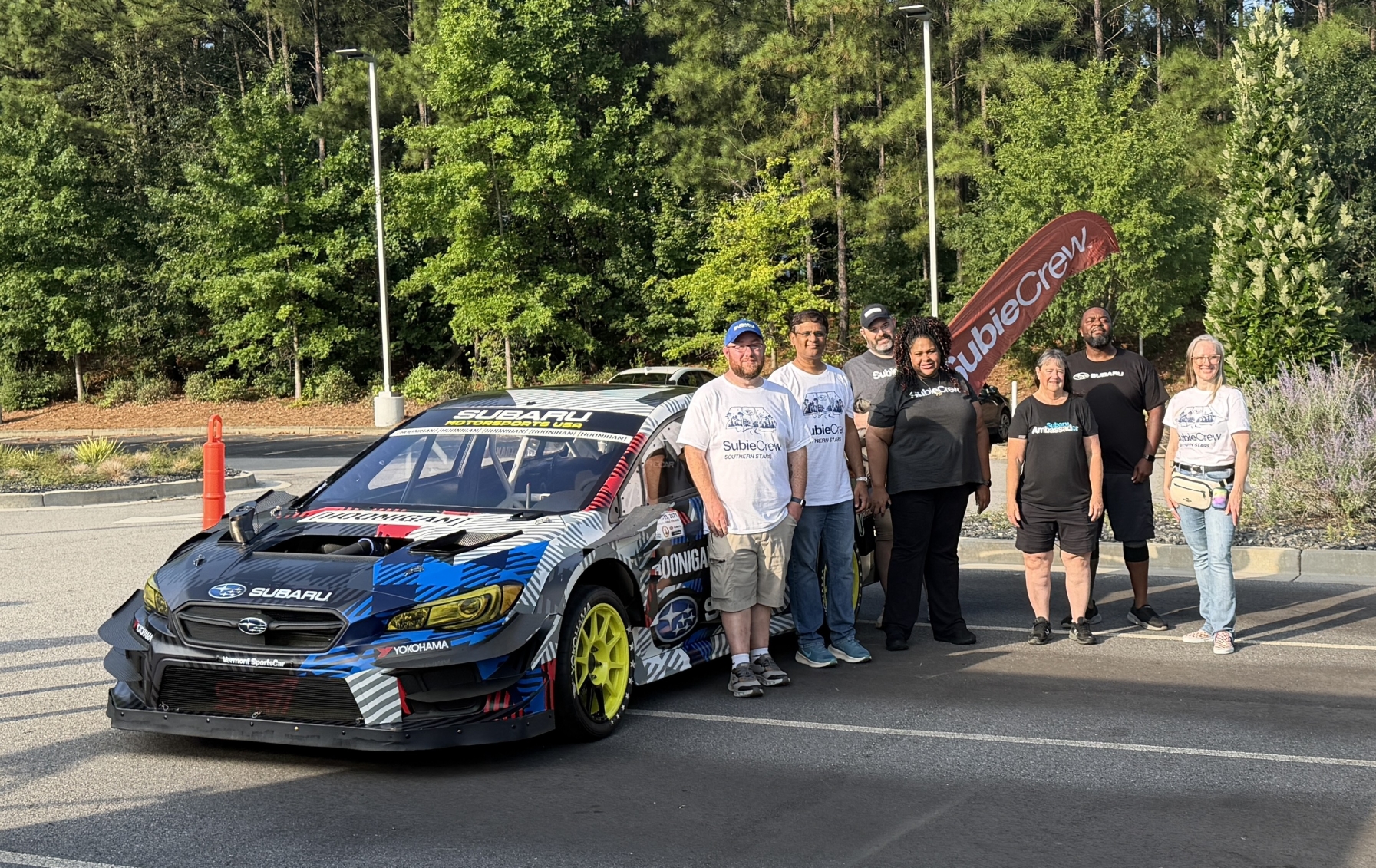 group of people standing next to a car
