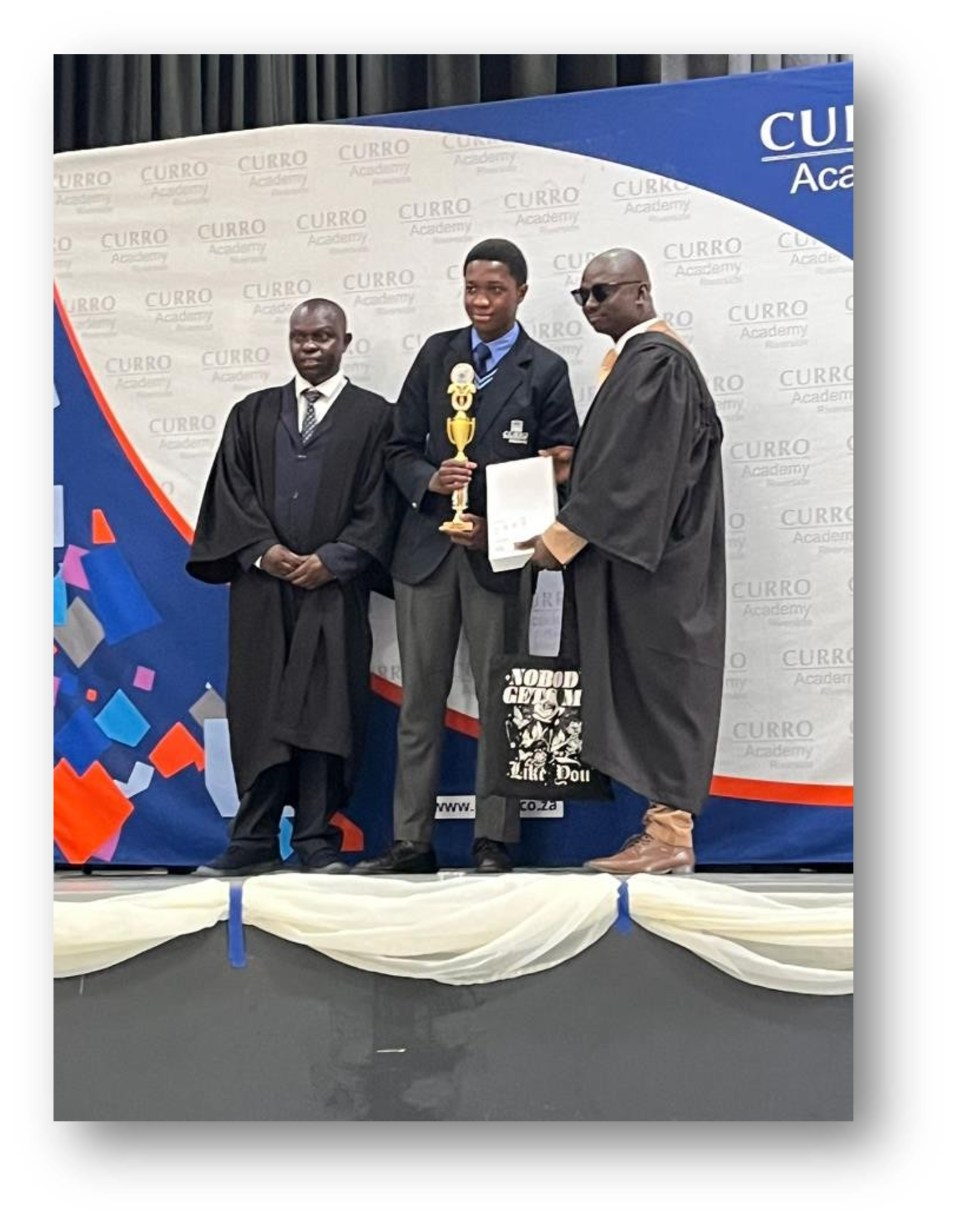 young man receiving trophy on stage