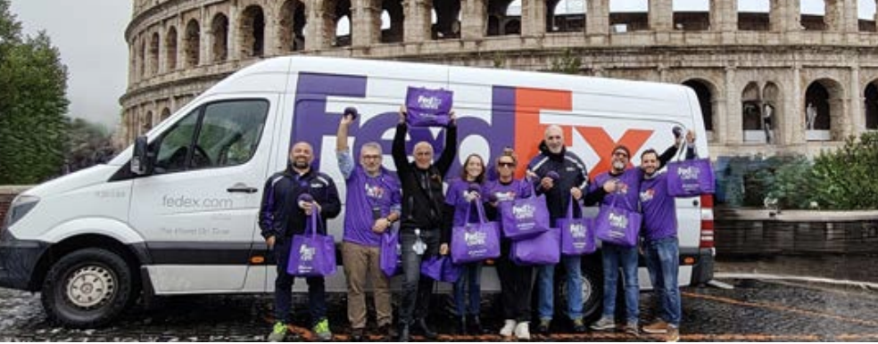 FedEx volunteers holding up purple totes