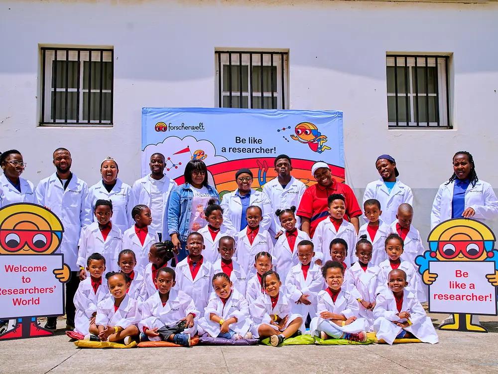 A group of students and instructors posing outside a building