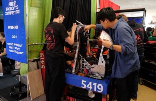 Wei (right) and his teammates at a robotics competition.
