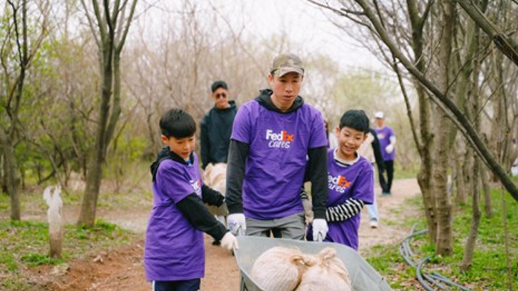 Volunteers pushing a wheelbarrow