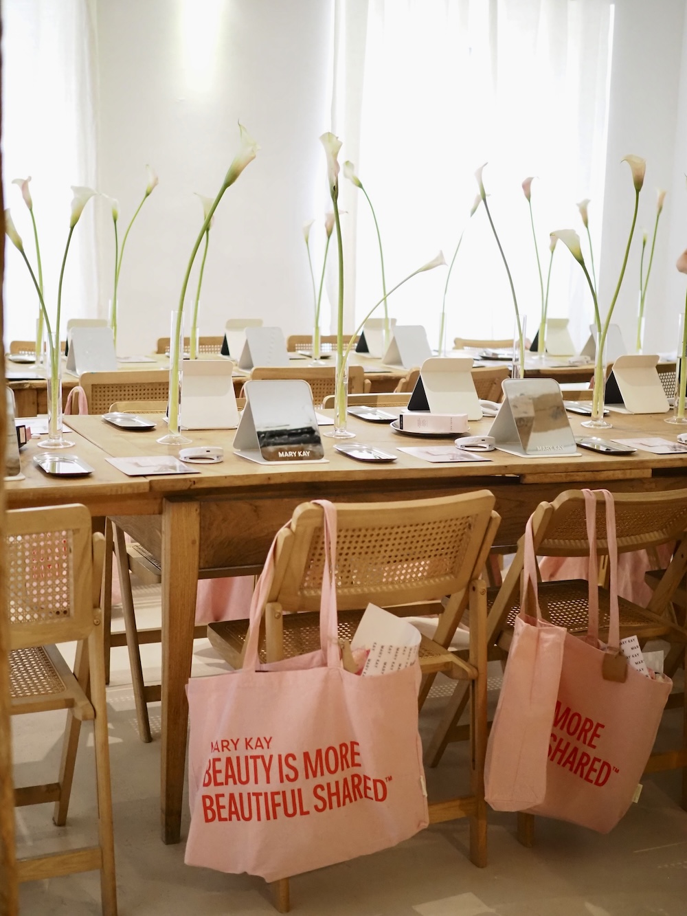 Table set with pink Mary Kay bags on each chair
