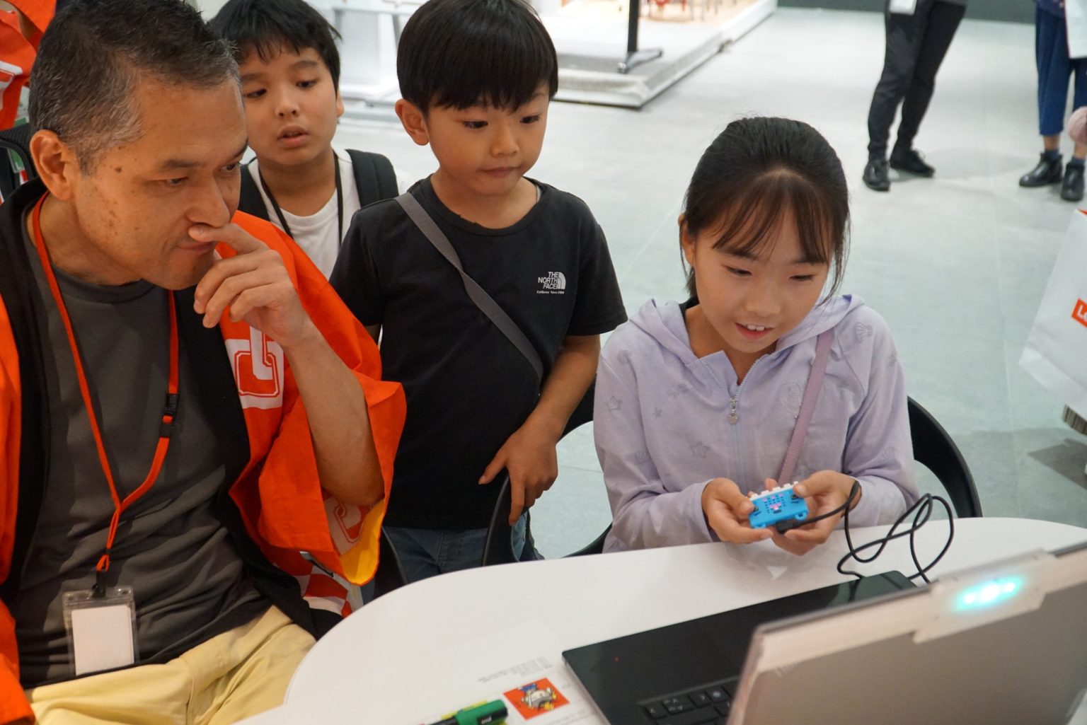 Adult working with kids on computer