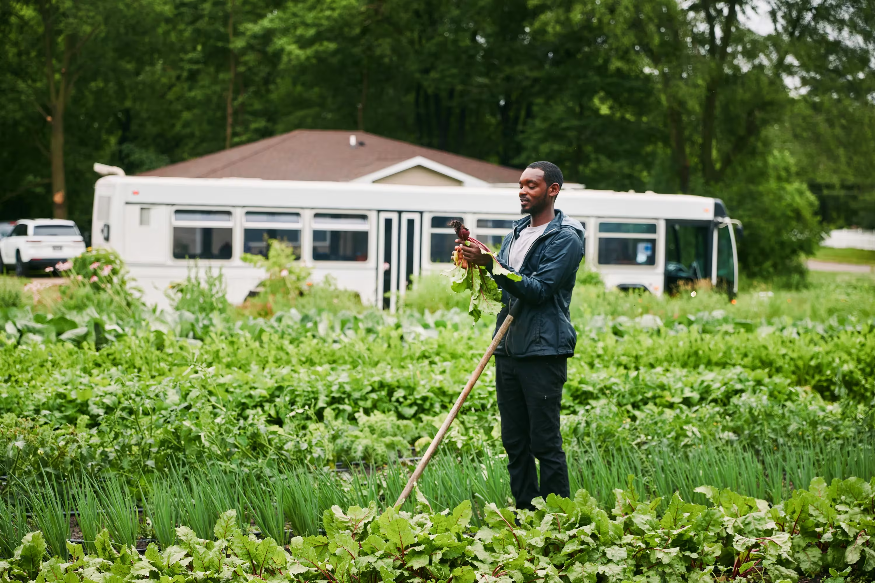 DaQuan Campbell holding a beet while working in a garden