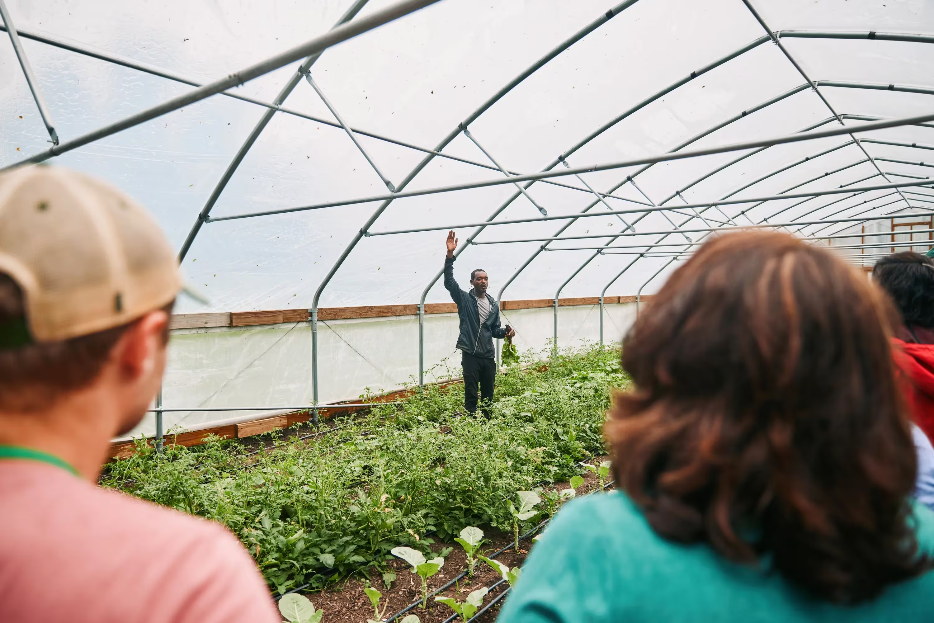 DaQuan Campbell talking to visitors inside a greenhouse