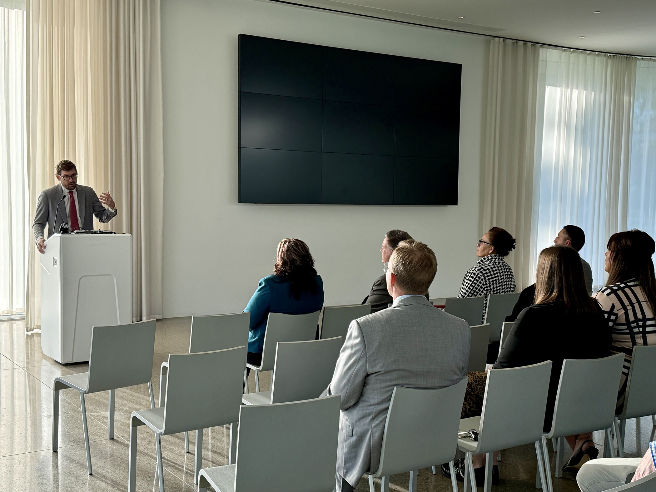 a person at a podium speaking to a seated group