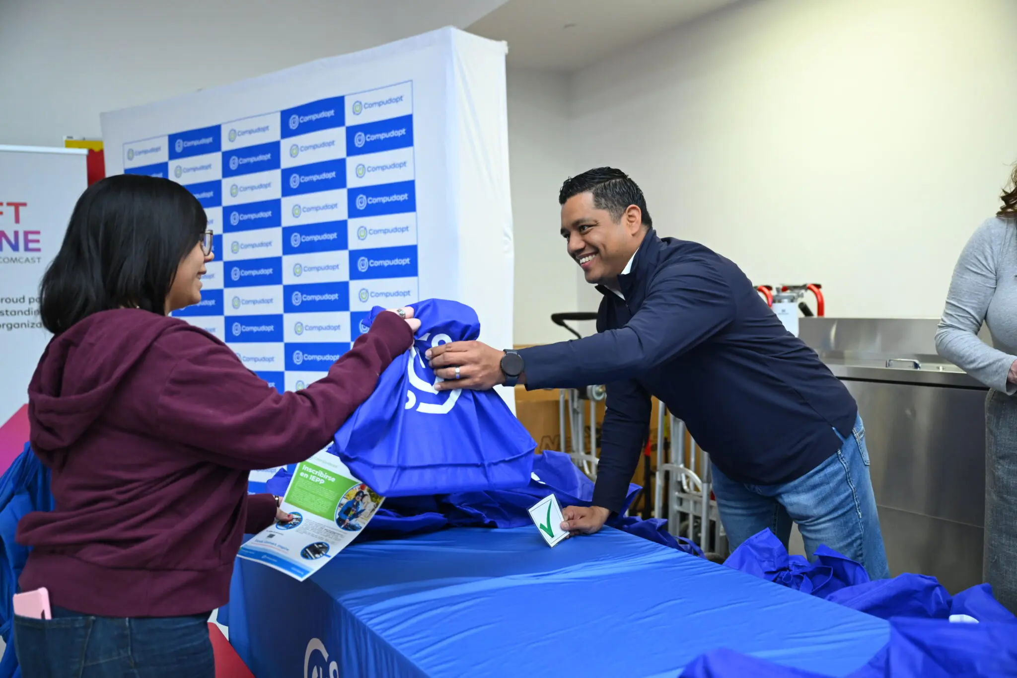 Person handing bag of tech supplies to student