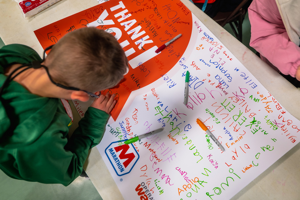 child working on a thank you card