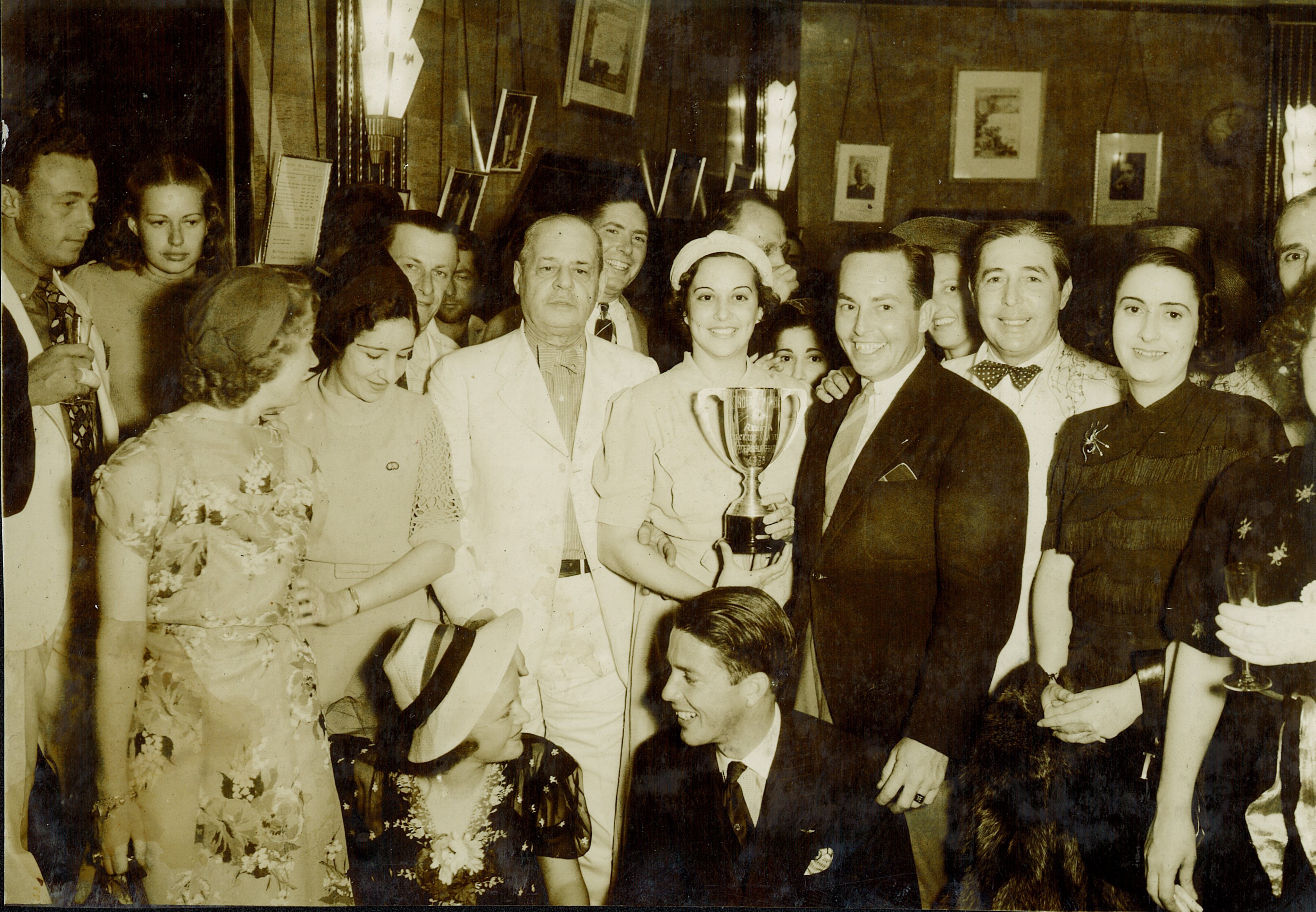 Photo from the Bacardi Archives: Winner of the 1938 Bacardi Cup and legendary sailor Harry Gale Nye Jr. (bottom center) celebrates with skippers, Rafael “Pappy” Valiente (center left in white) and other competitors at the Bacardi Bar inside Edificio Bacardí in Havana. 