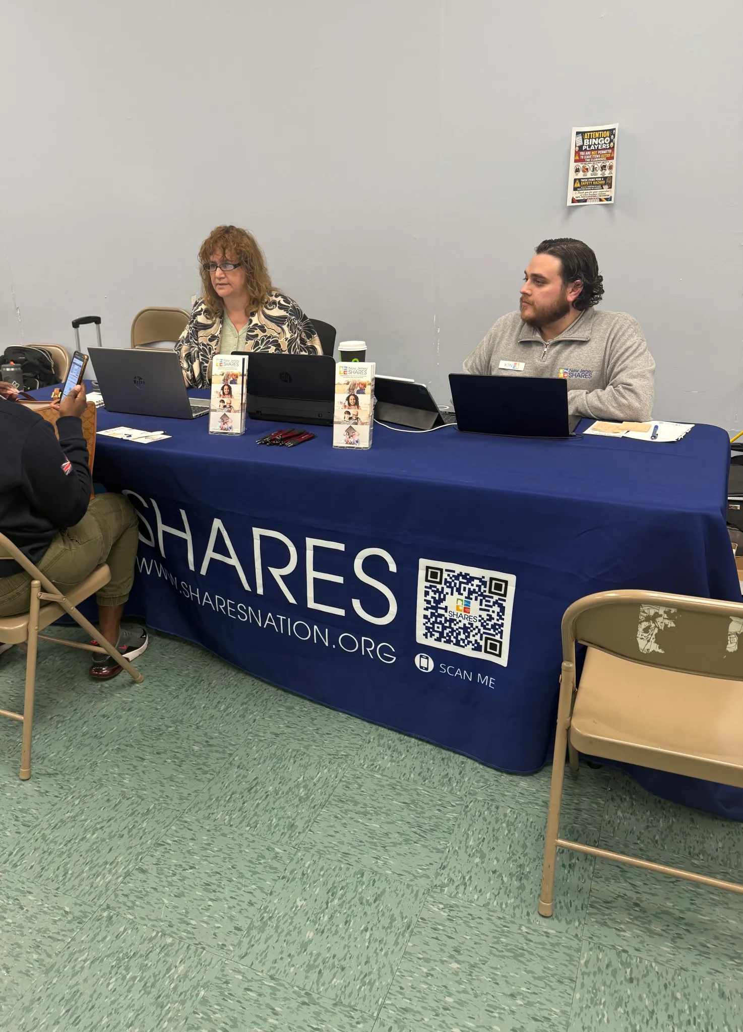 People with open laptops at SHARES Nation booth
