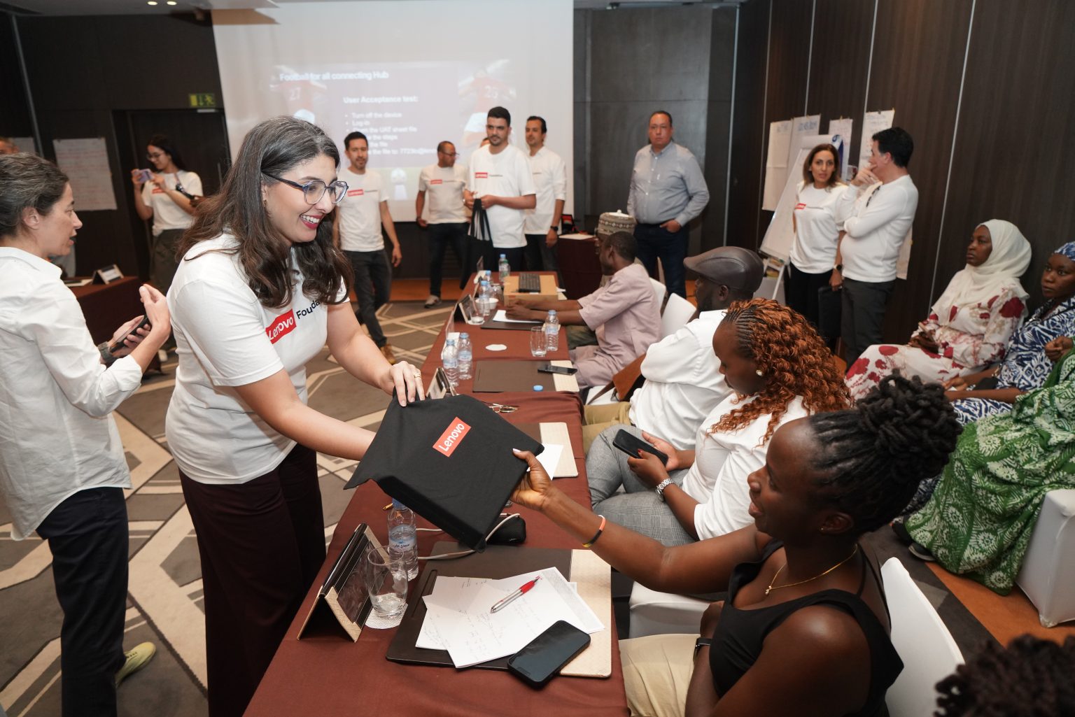Lenovo volunteer present FFALP participant with a Lenovo laptop