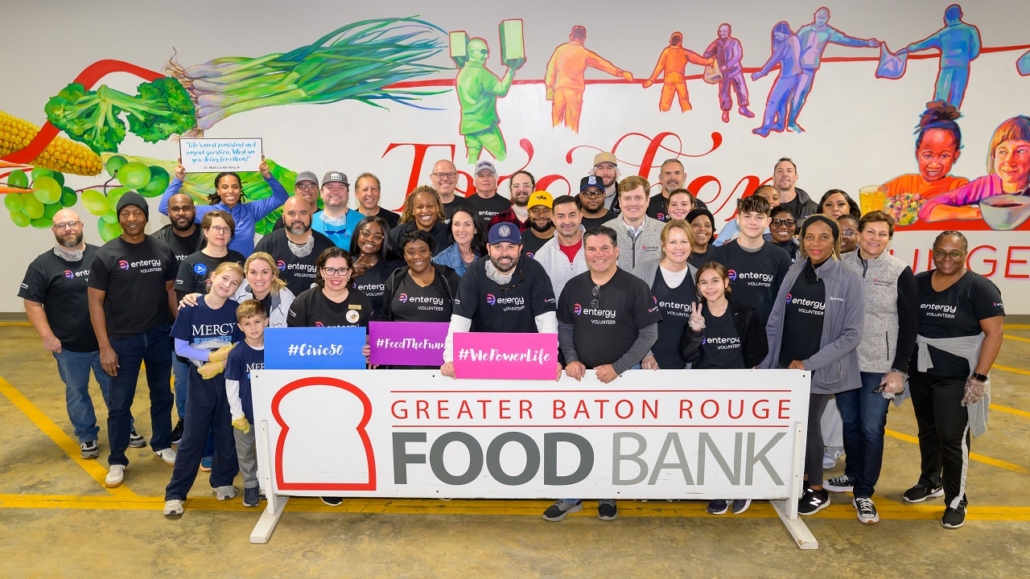 Volunteers posing behind a Greater Baton Rouge Food Bank sign
