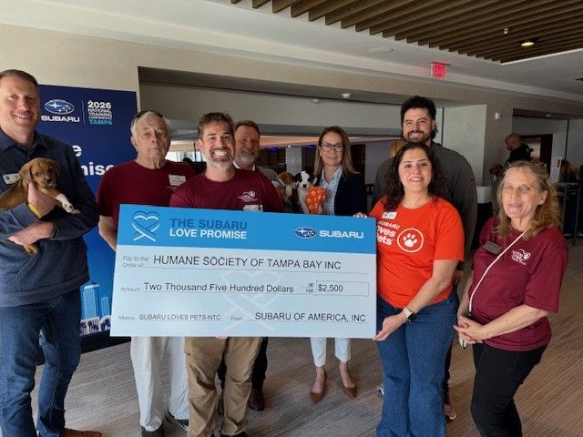 People holding up oversized check made out to HUMANE SOCIETY OF TAMPA BAY INC