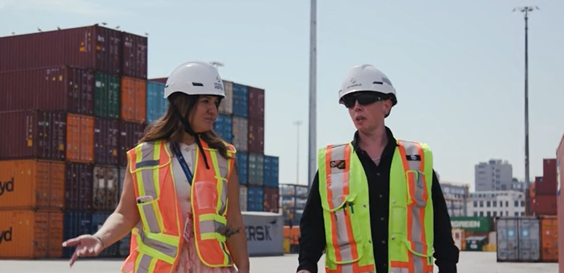 Two female DP World employees walk the container yard
