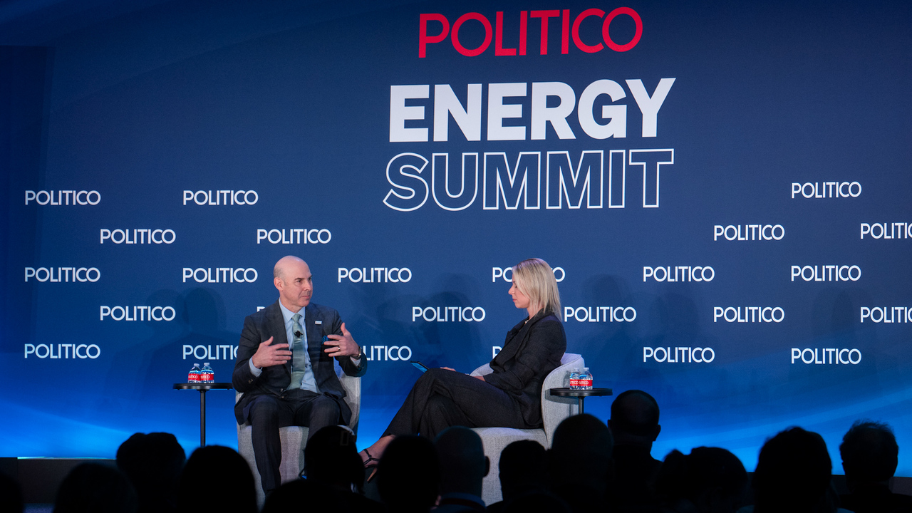 people sitting on stage at Energy Summit
