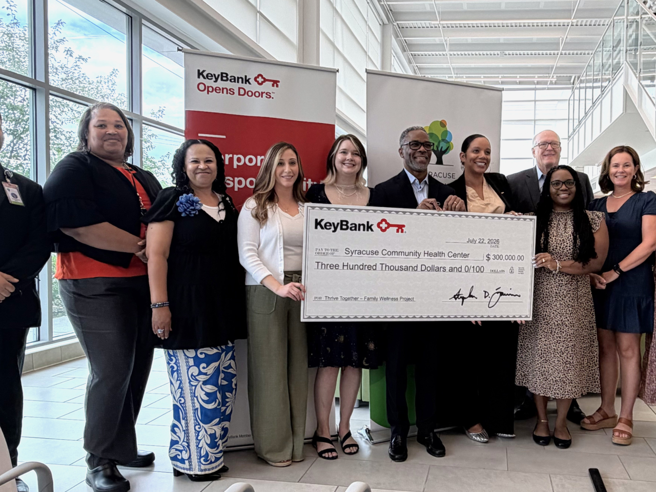 people holding up decorative check at event