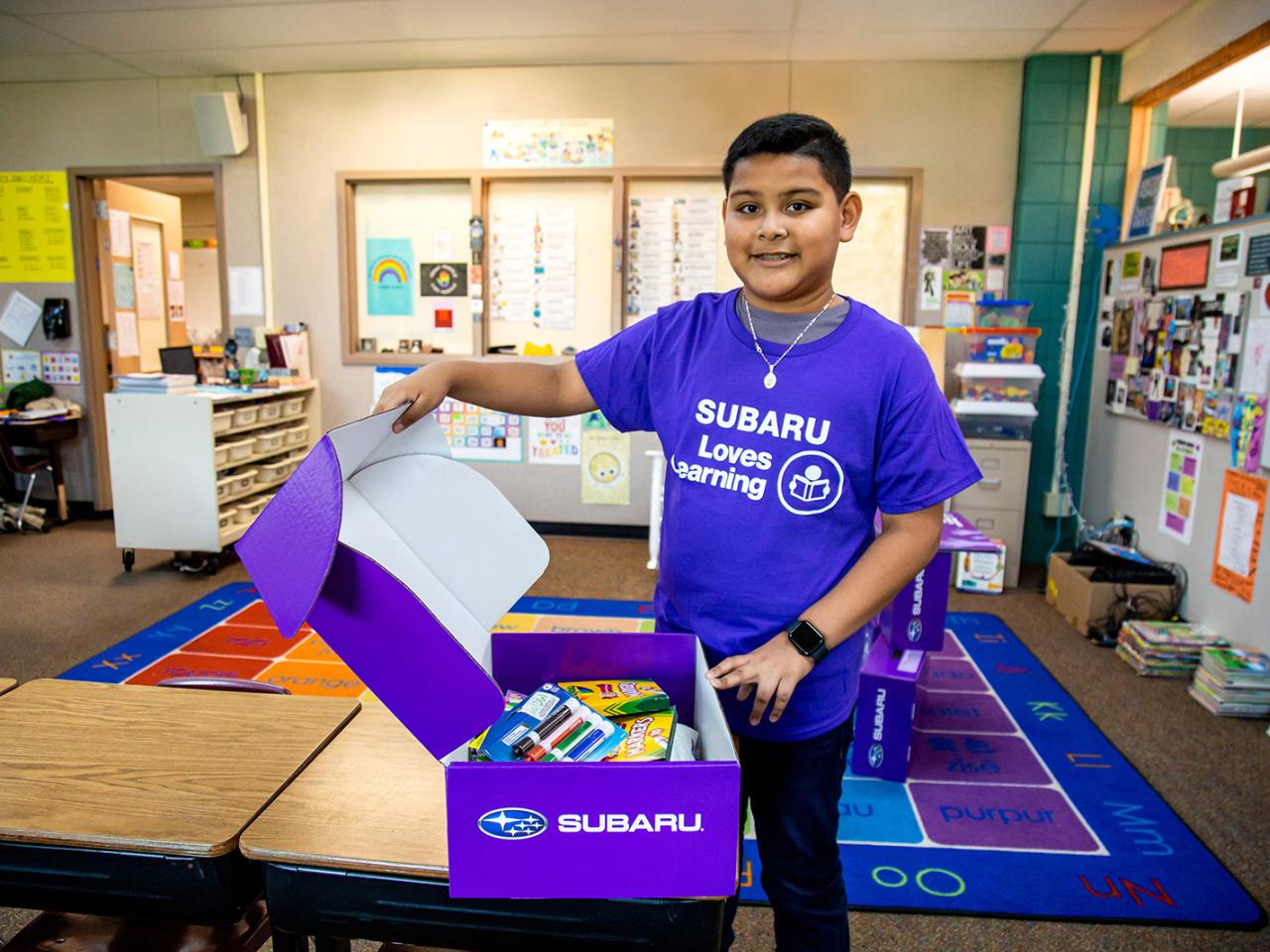 A child opening a purple box with supplies in it