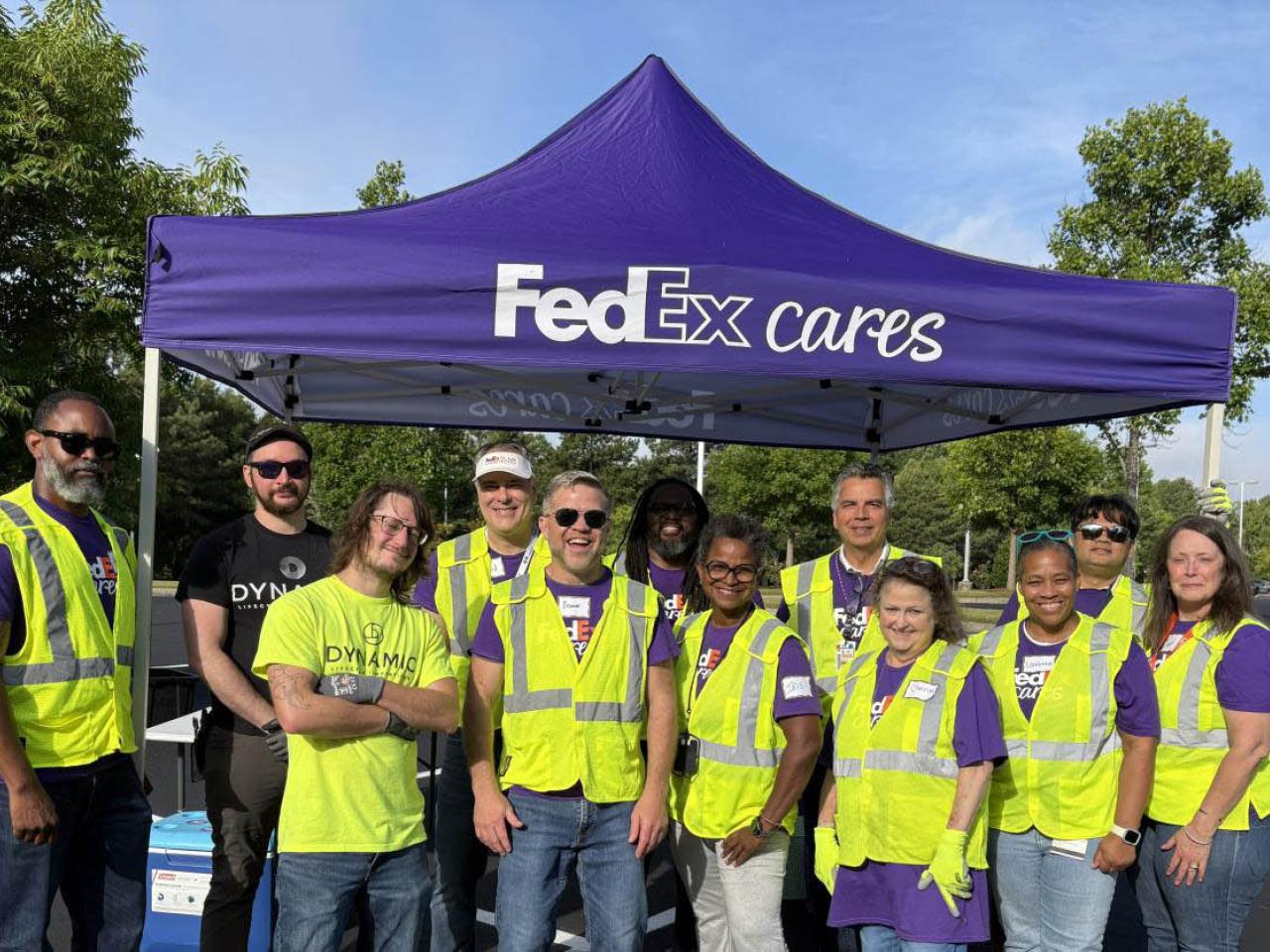 Volunteers outside next to a "FedEx Cares" tent