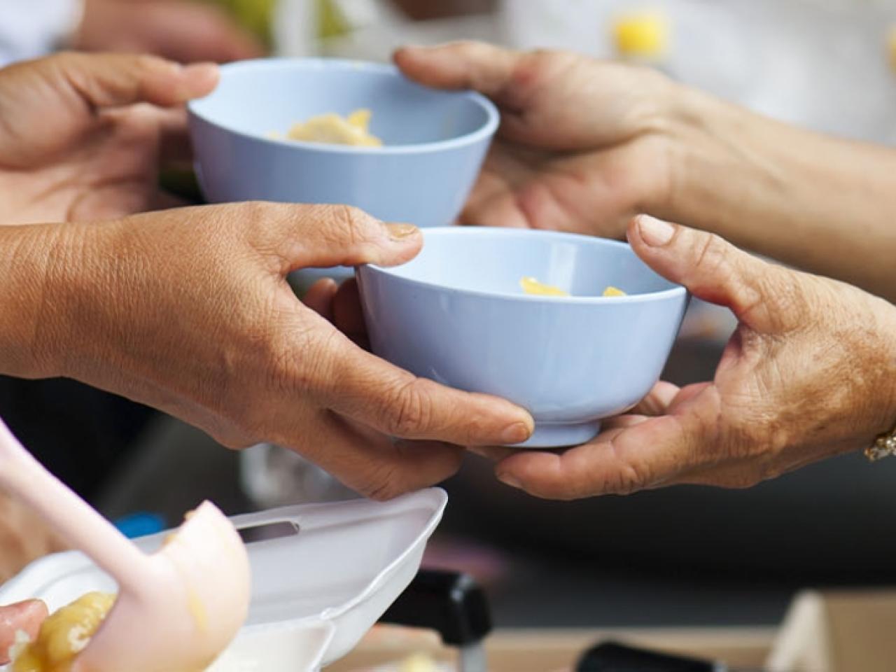 Hands sharing bowls of food