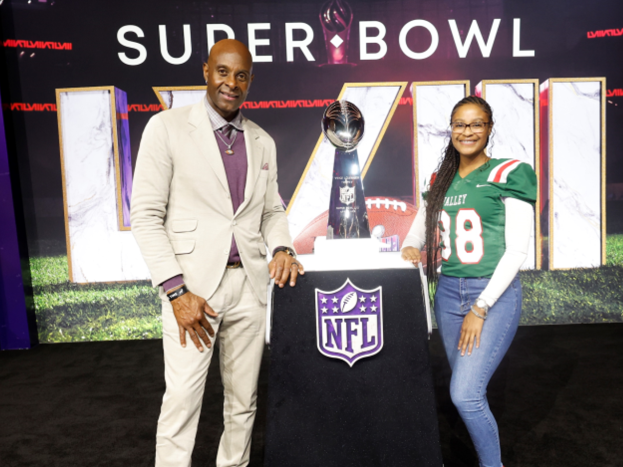 Two people stood near the super bowl trophy 