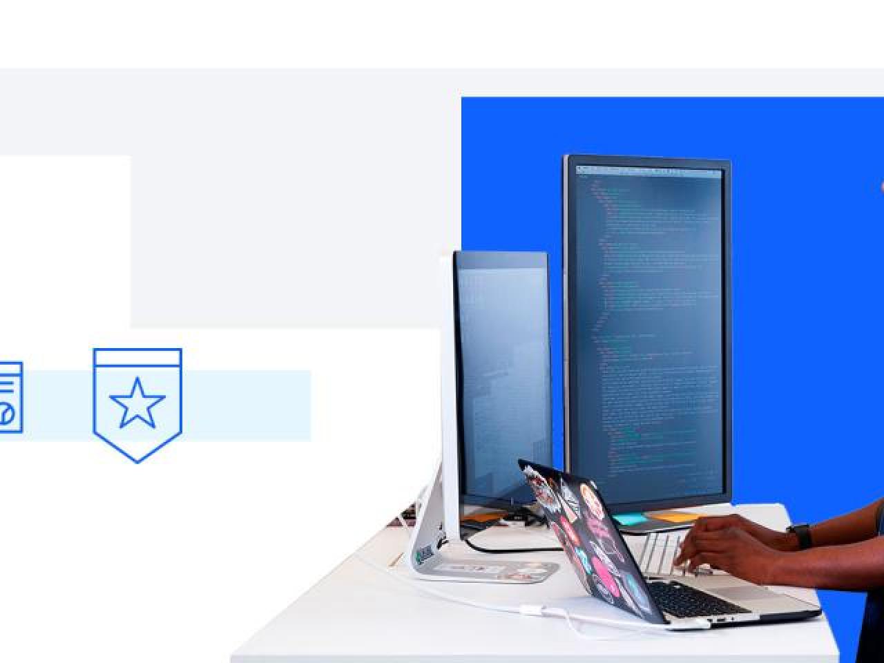 person typing at computer facing multiple monitors