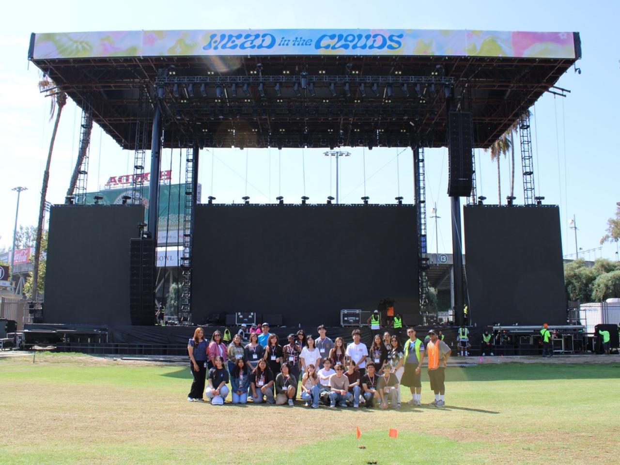 Students and event staff gather in front of the Head in the Clouds main stage during a behind-the-scenes venue tour.