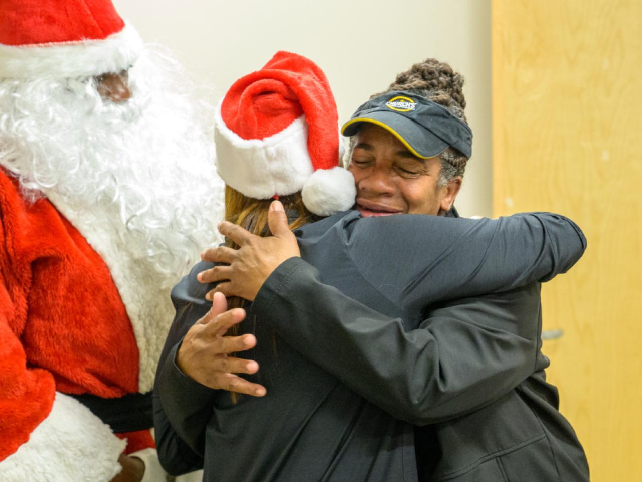 Cusomter hugging Entergy official wearing Santa
