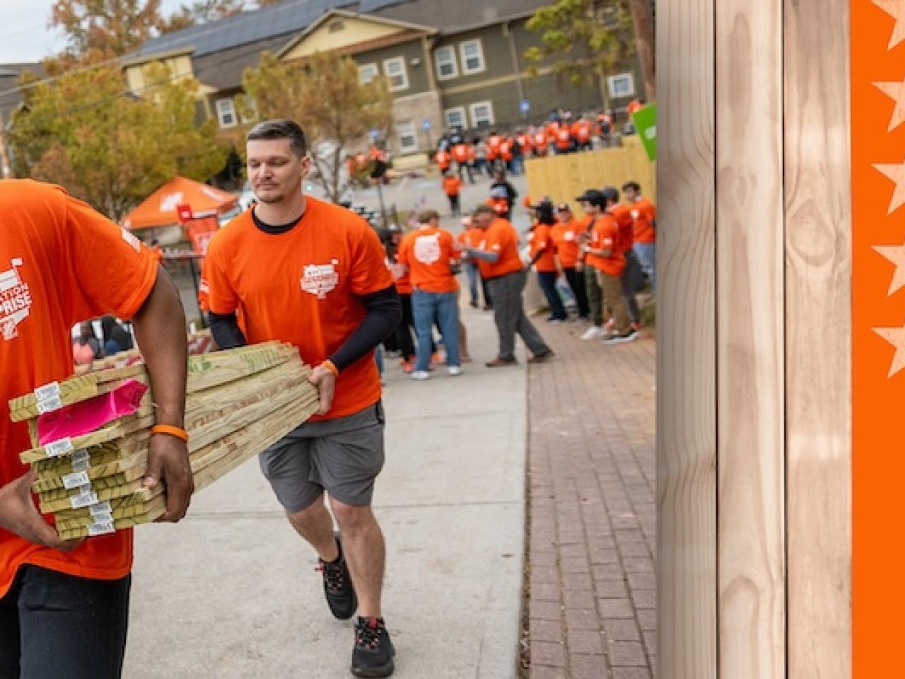 Operation Surprise! The Home Depot volunteers shown carrying lumber.