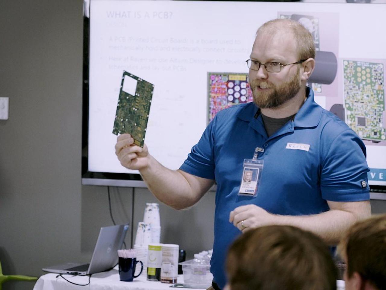 Presenter showing off circuit board