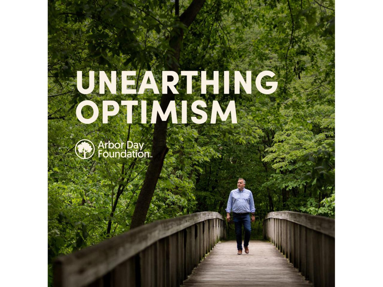 CEO of Arbor Day Foundation walks across a bridge, surrounded by trees in Unearthing Optimism podcast cover.