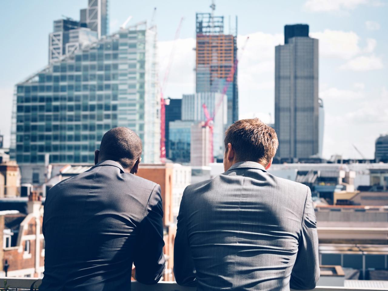 Two businessmen looking at skyline