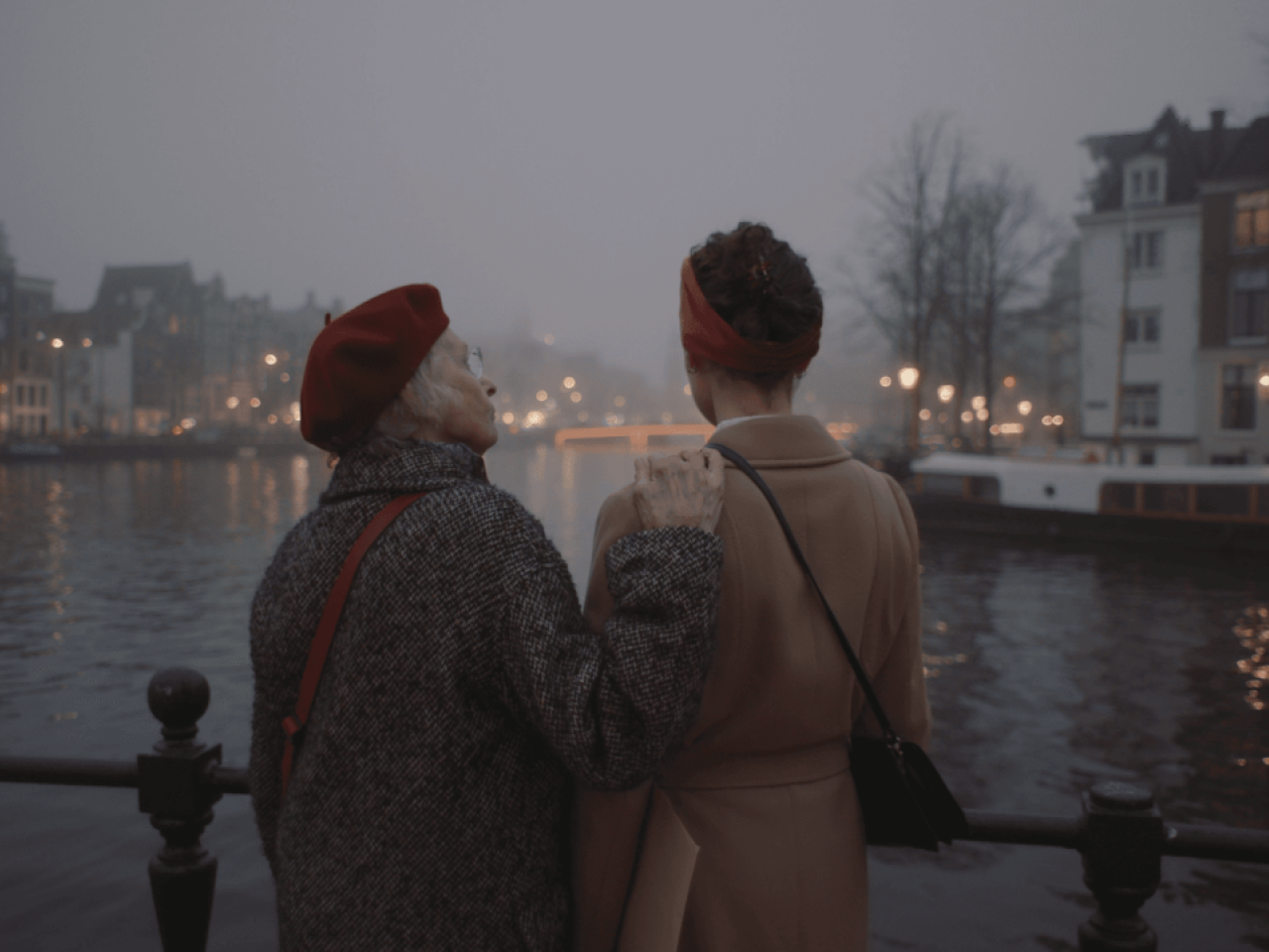 Two people talking while looking out at water