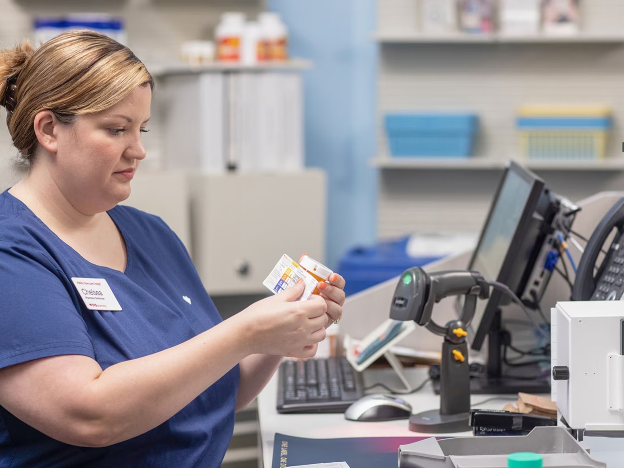 Employee putting a label on a pill bottle