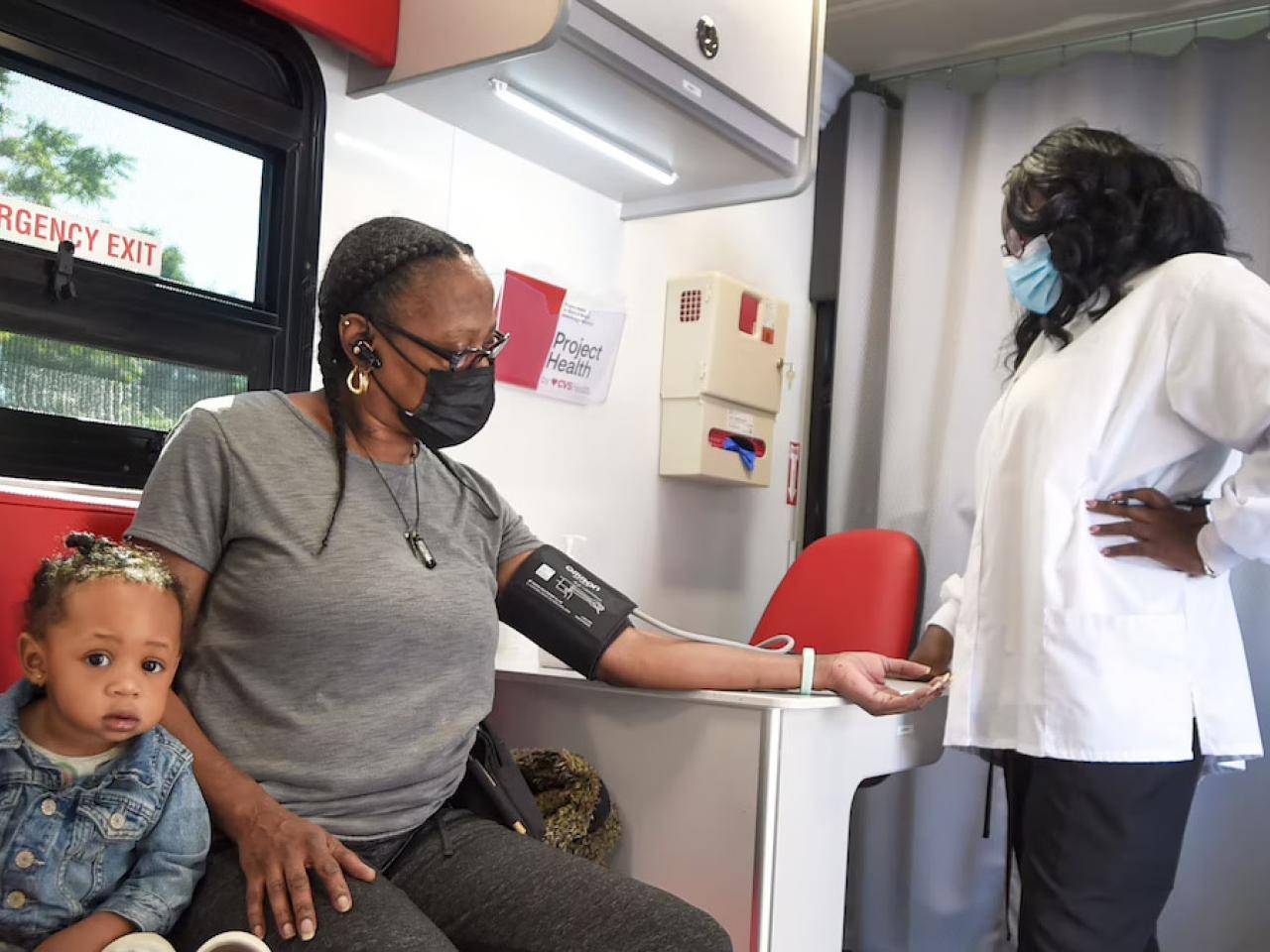 Patient shown with her daughter having her blood pressure checked.
