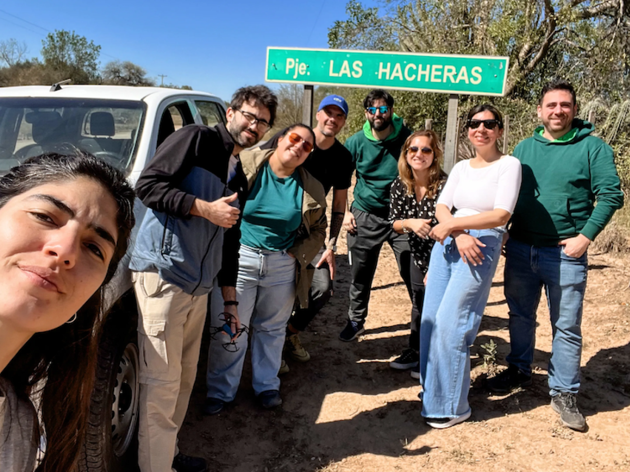 group photo on side of the road by car