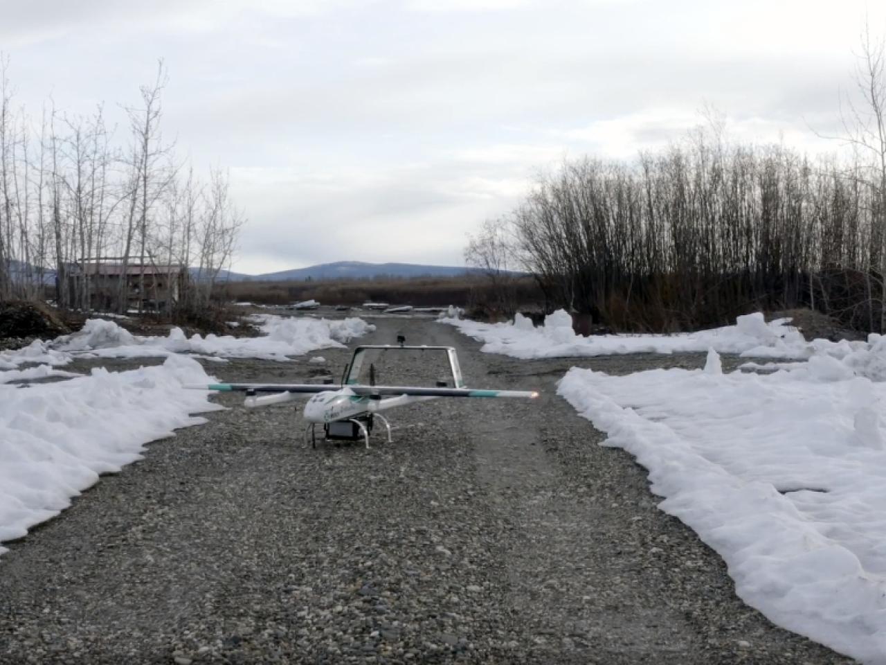 A drone on a cleared path with snow surrounding.
