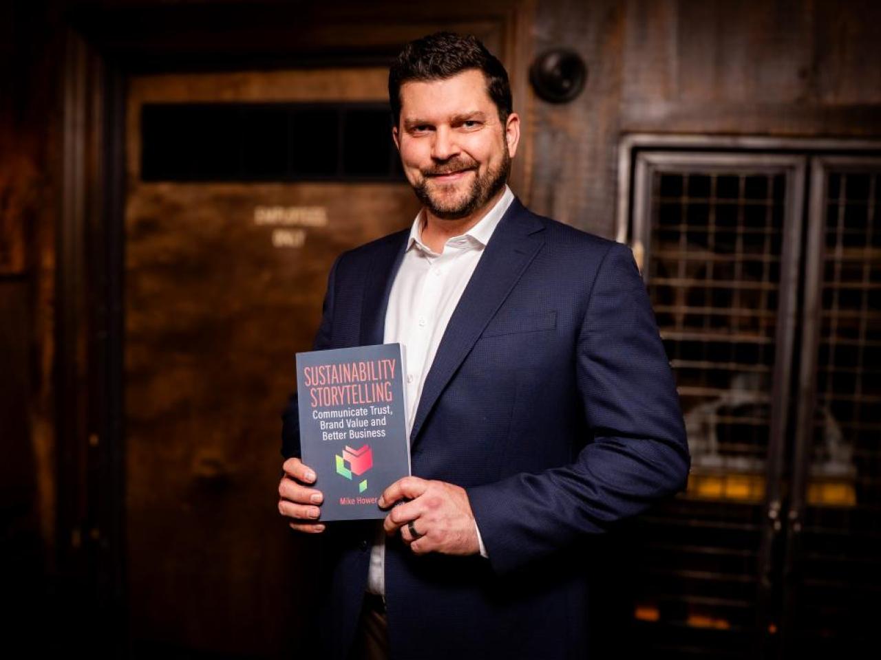 Mike Hower holding his new book