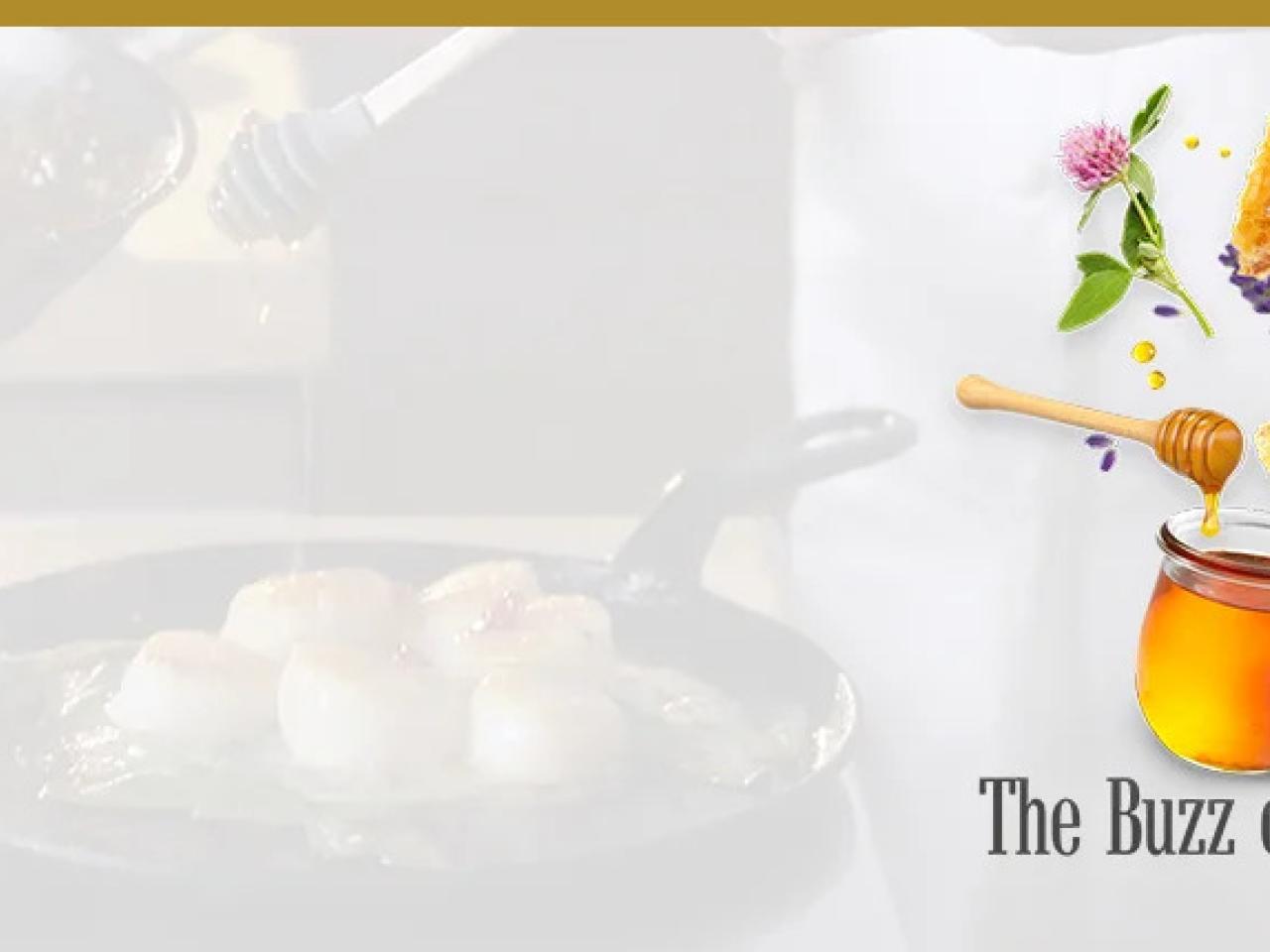 A faded background of a pan on a stove "The buzz on Honey" and honey pot and flowers.