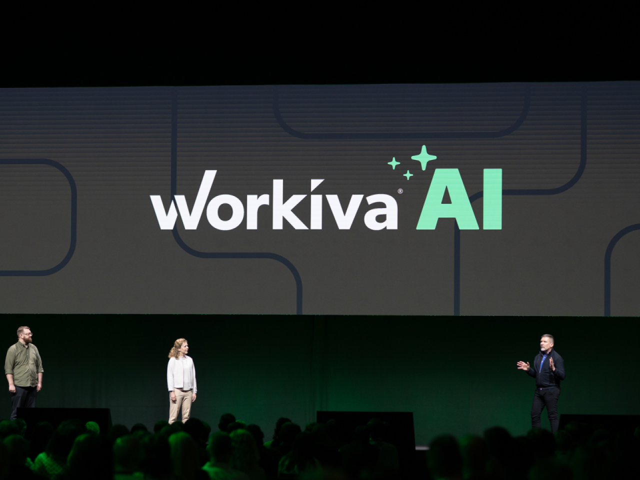 People on a stage with "Workiva AI" behind them