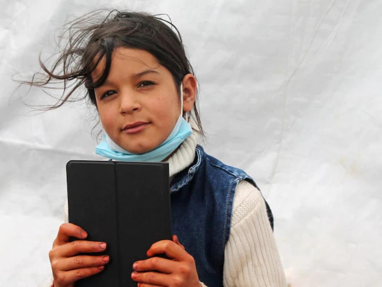 A child holding an electronic tablet