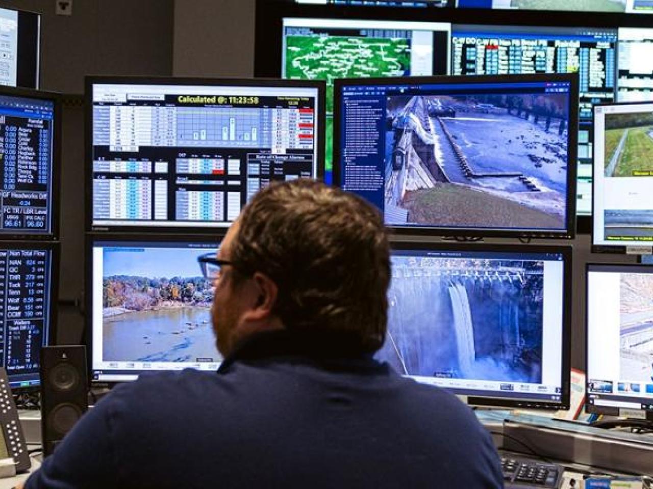 Someone sitting in front of many screens