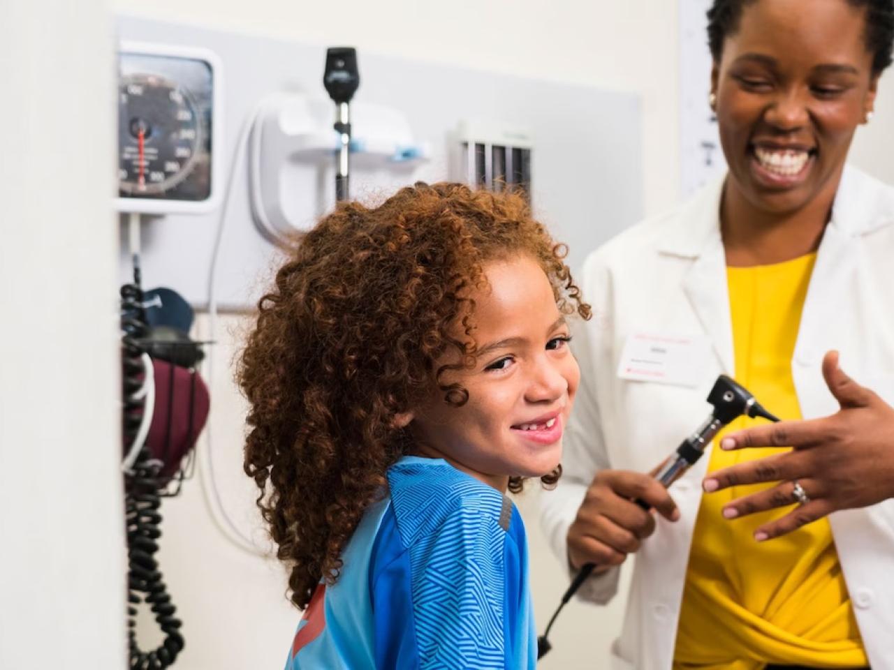 A young girl being examined by a doctor.