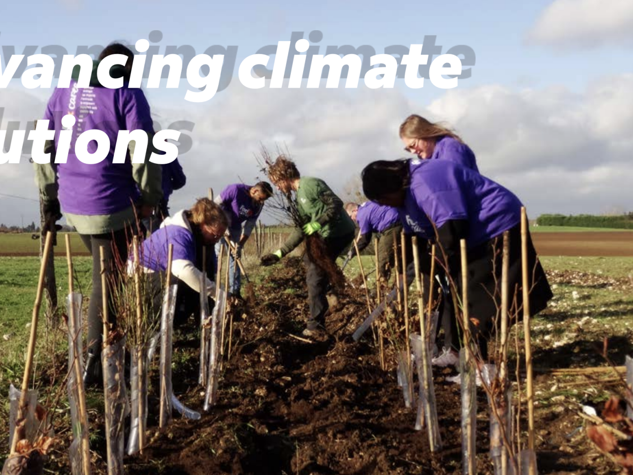 "Advancing climate solutions" with picture of people planting together