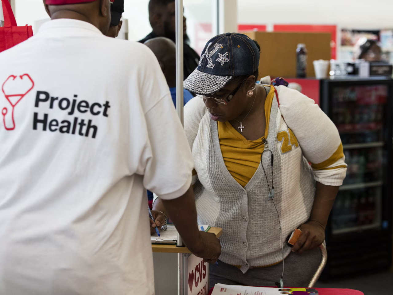 Person wearing Project Health shirt helps someone to sign up
